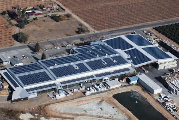 Aerial view of a rooftop commercial solar system installed by Coldwell Solar on an agricultural industrial building in California.
