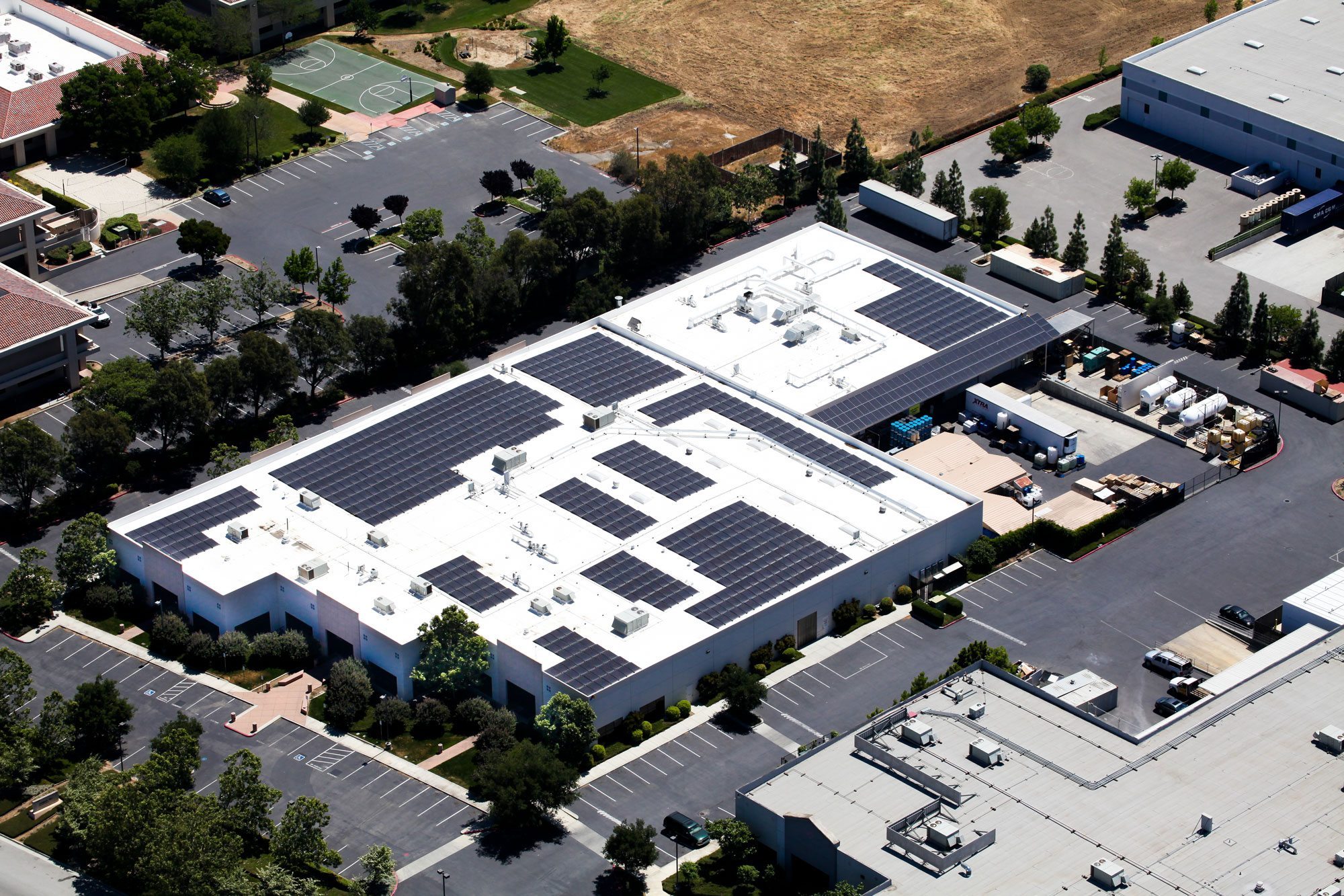 Aerial view of California commercial building with rooftop solar panels.