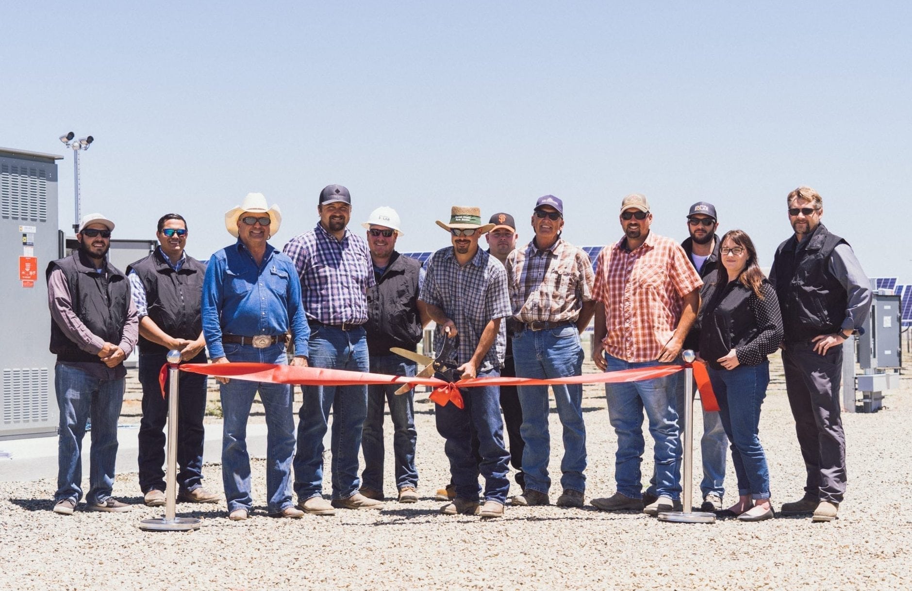 A group of employees from Pedretti Ranch in El Nido, California standing at the ribbon cutting ceremony in front of their new solar system.