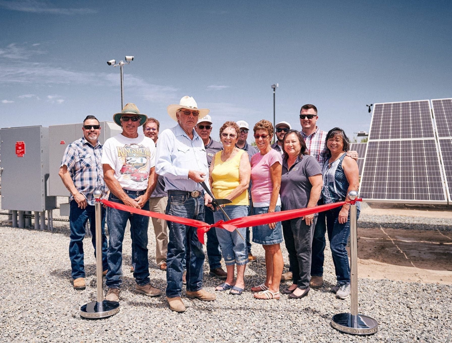 A group of employees from Hanse Farms in Hanford, California standing at the ribbon cutting ceremony in front of their new solar panels.