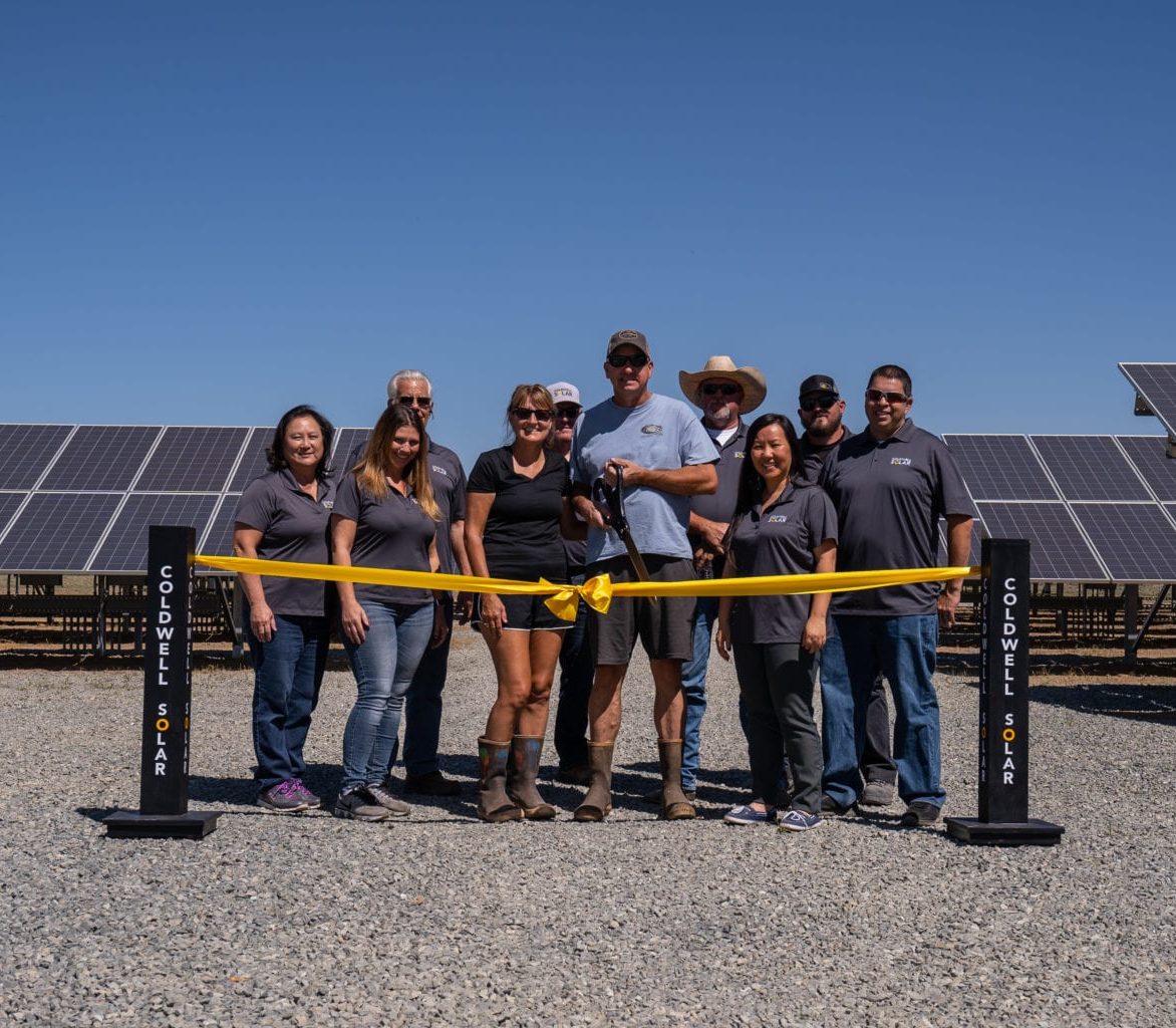 A group of people standing at the ribbon cutting ceremony for newly constructed solar array at Skyview Dairy in Shafter, California.