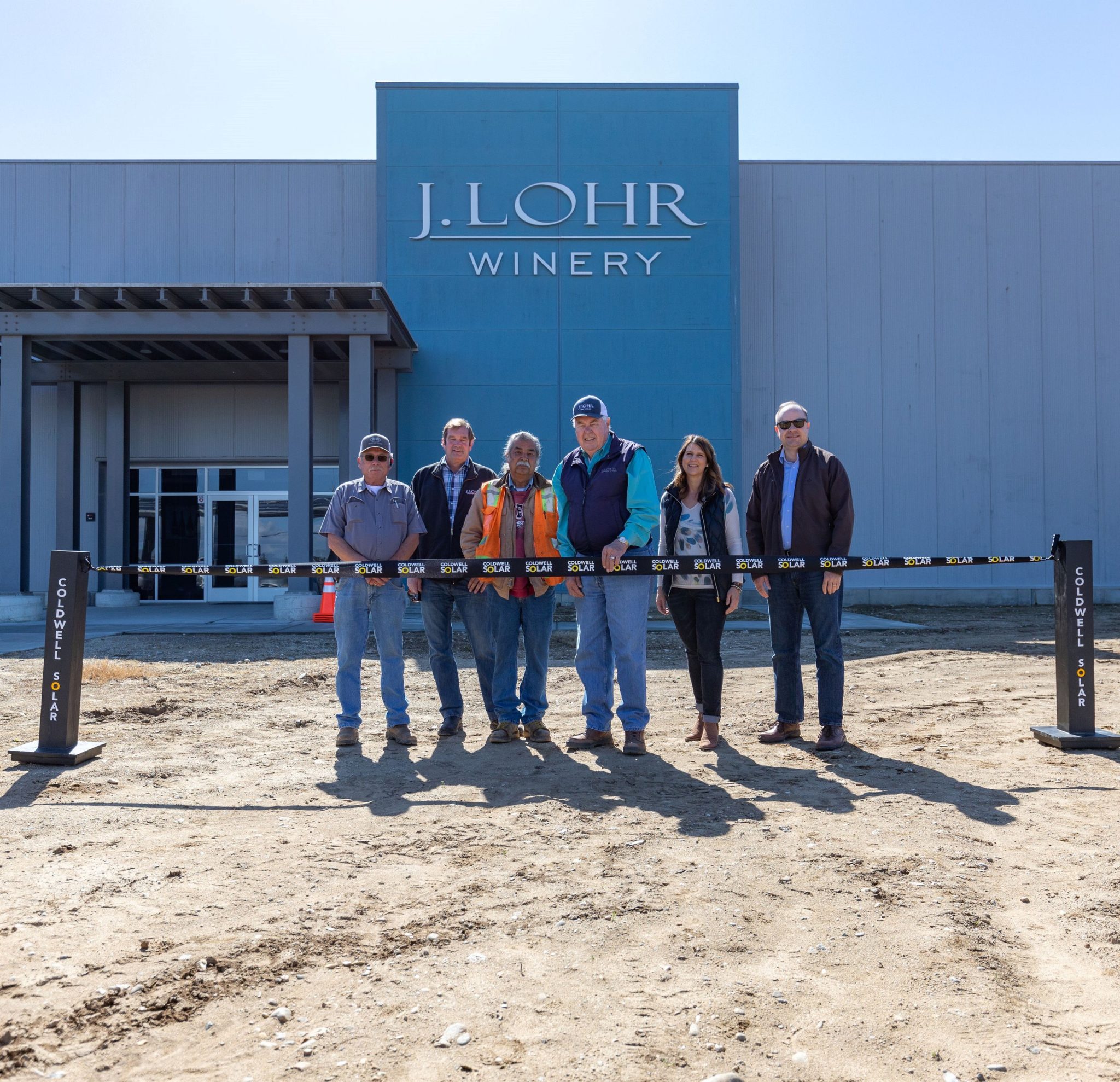 Employees of J Lohr Vineyards standing in front of their winery at the ribbon cutting ceremony for their new solar installation.