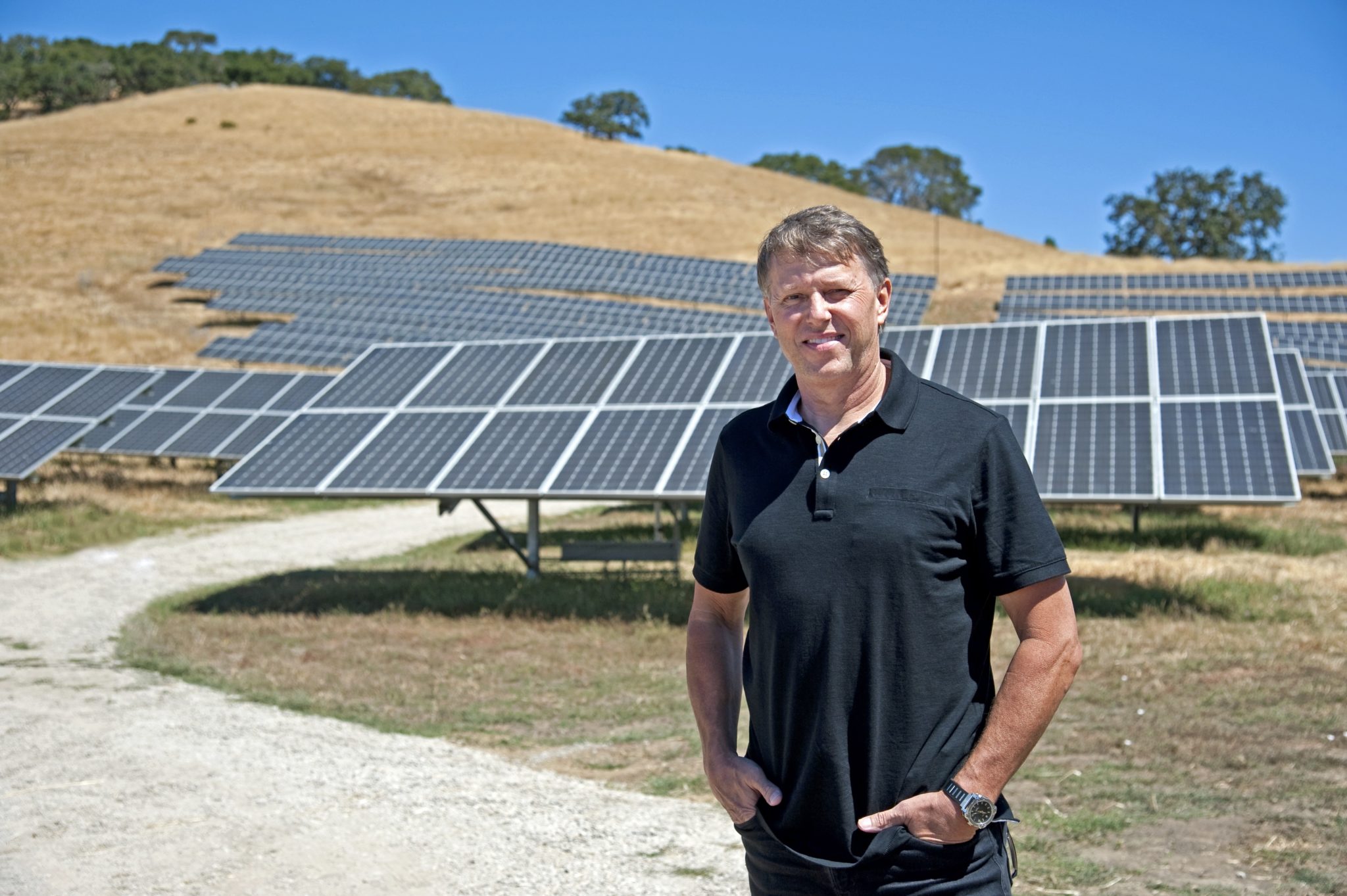 Man standing in front of utility-scale solar installation in northern California.