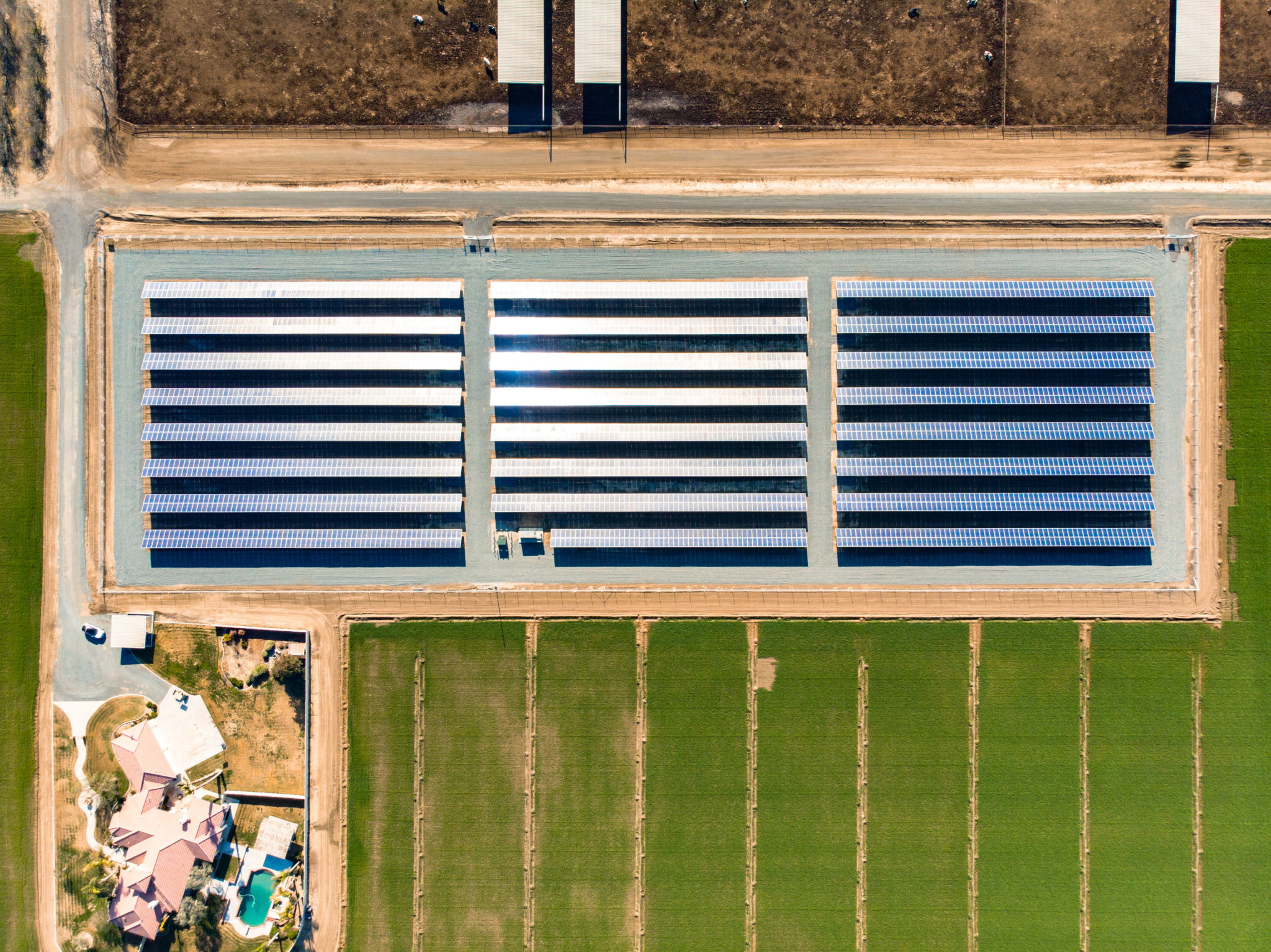 Aerial view of solar installation at Peter DeJong Dairy surrounded by green pasture land.