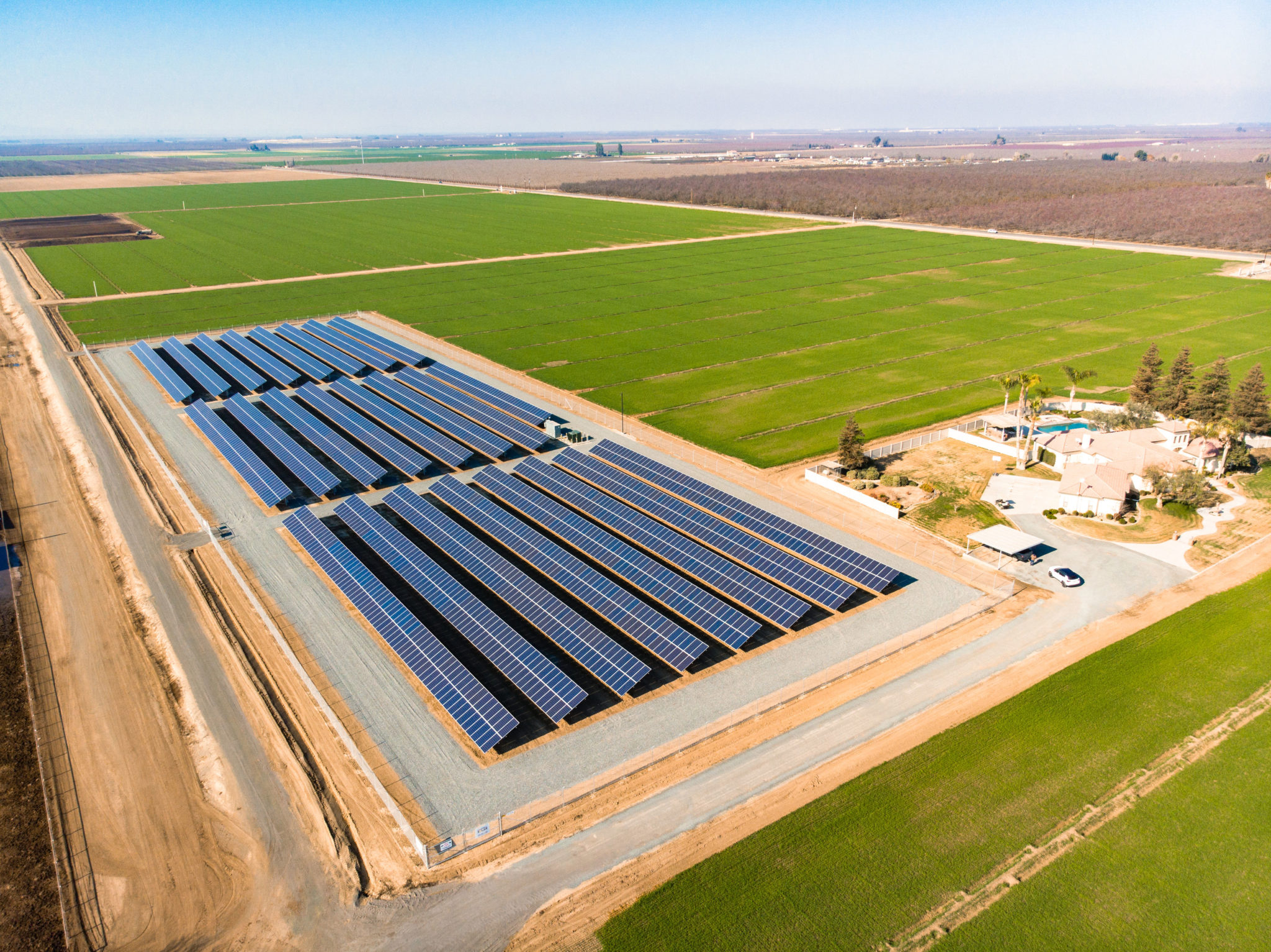 Aerial view of small solar farm constructed at a dairy farm on California agricultural land.