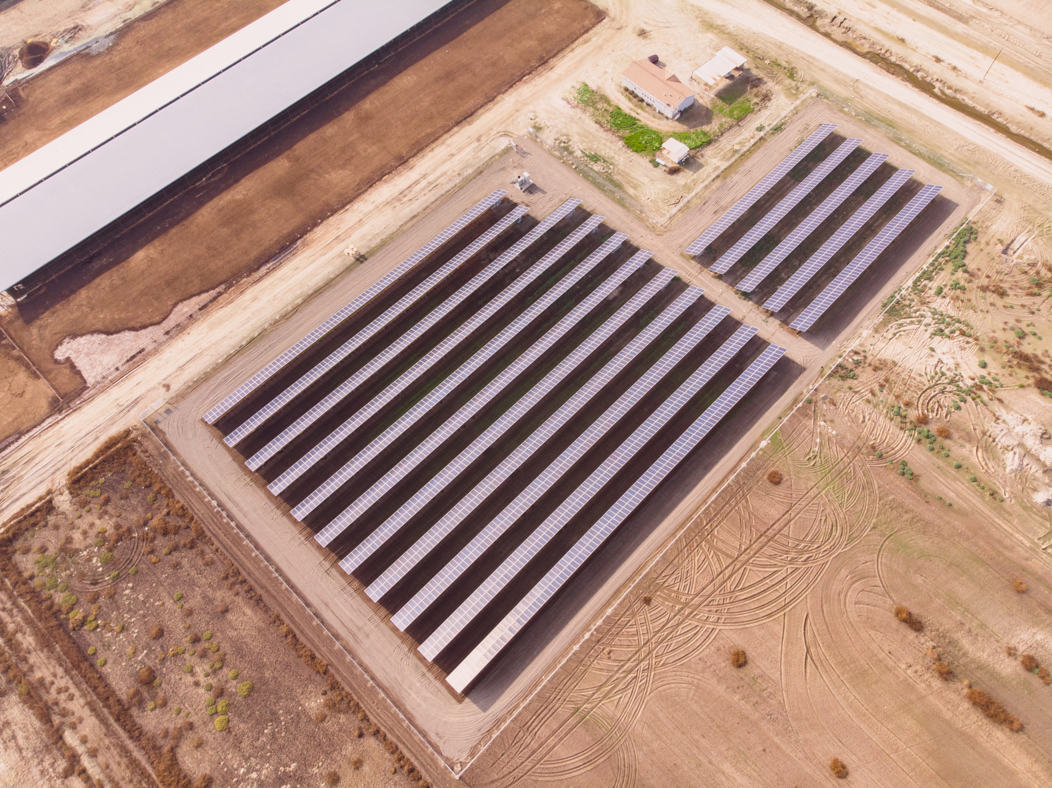 Aerial view of the solar installation surrounded by brown farmland at Lakeshore Dairy in Hanford, California.