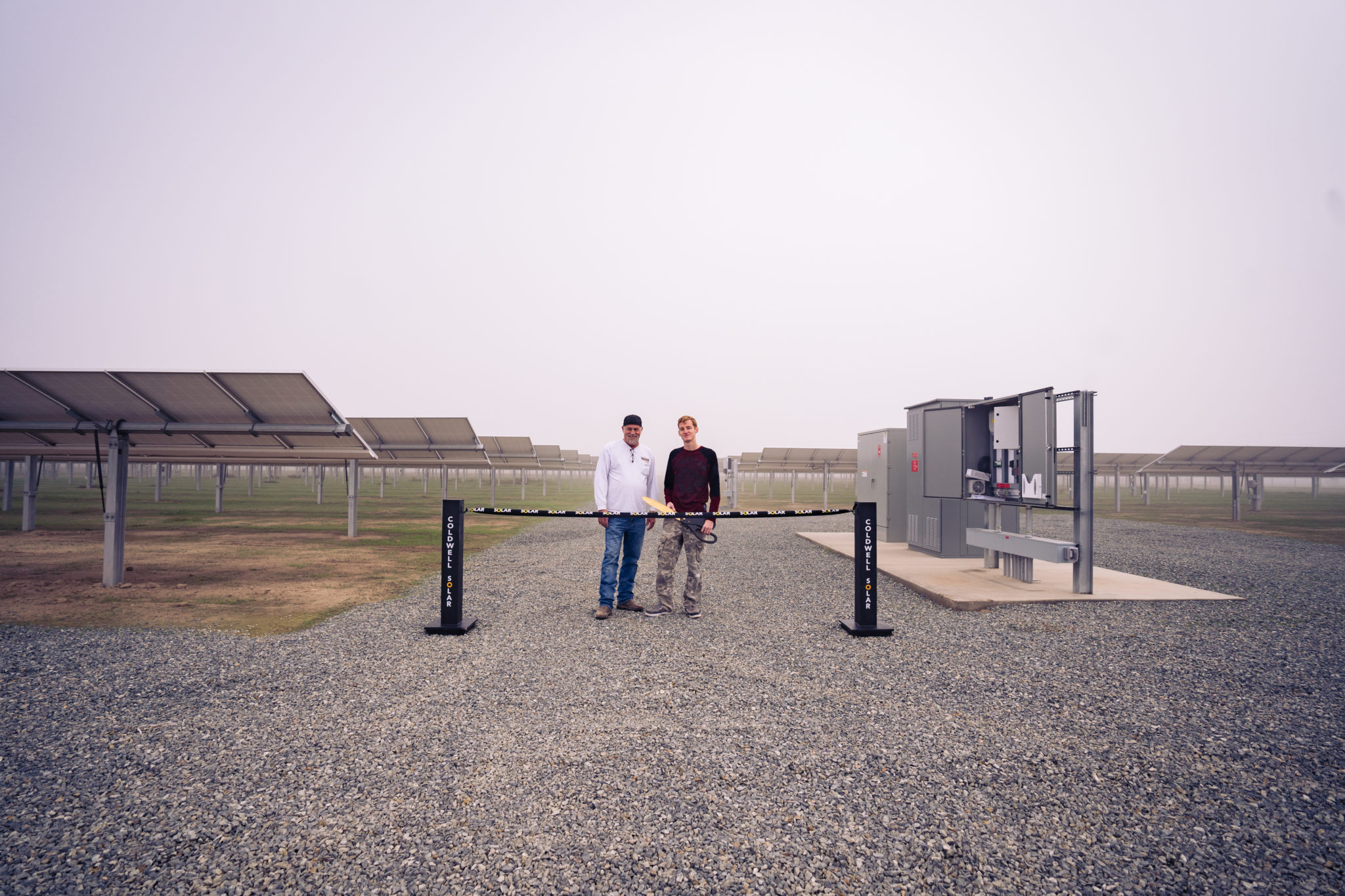 Two men about to cut ribbon on completion of a dairy farm solar installation in Pixley, California.