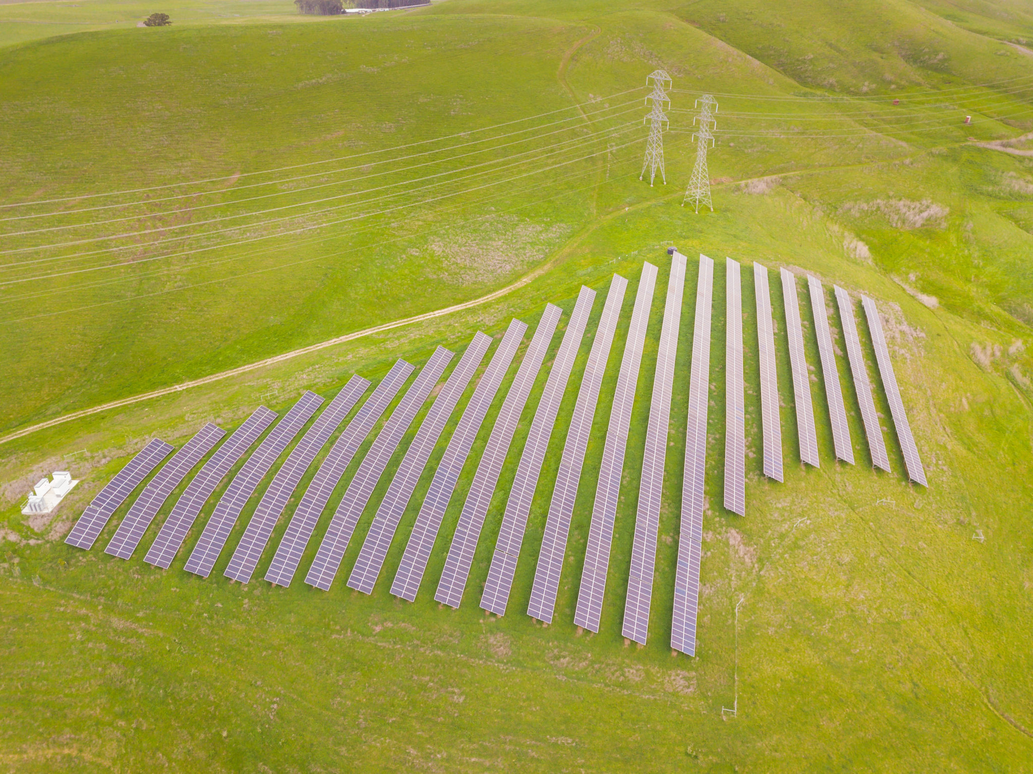 Aerial view of a solar farm among green rolling hills in Petaluma, California.