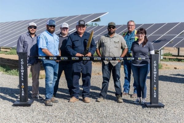 Employees of Iyer Farms at the ribbon cutting ceremony in front of their new solar farm installation.