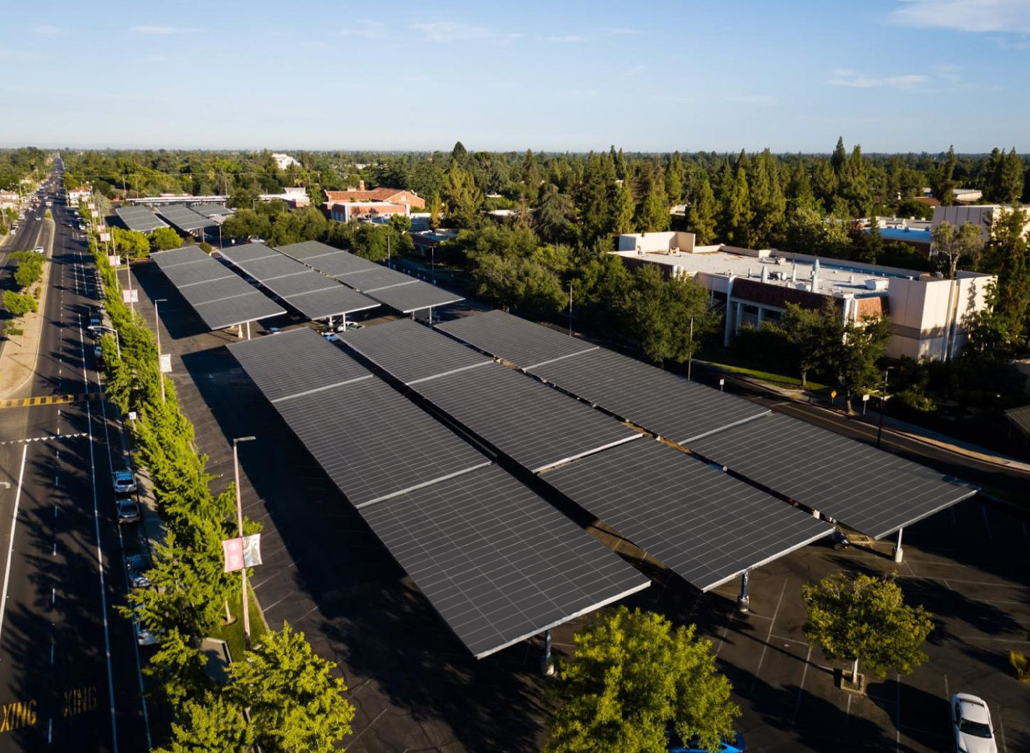 Solar panel carport surrounded by businesses and wooded areas in California.