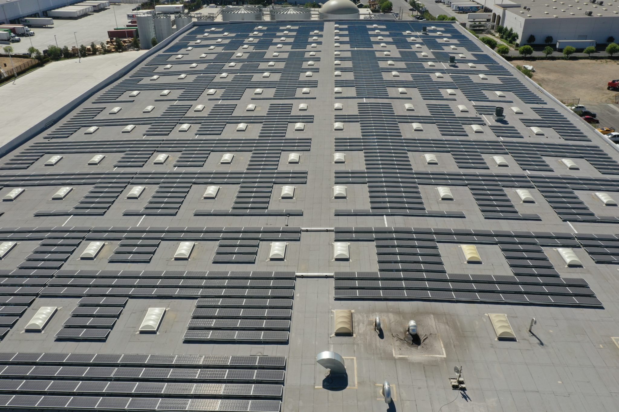 Closeup aerial view of solar array on the rooftop of a California warehouse.