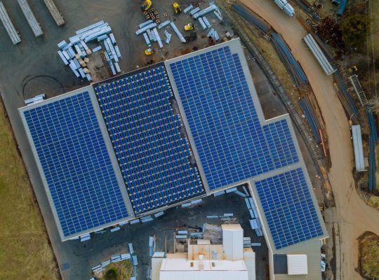 Aerial view of solar panels covering rooftop of a commercial building. 