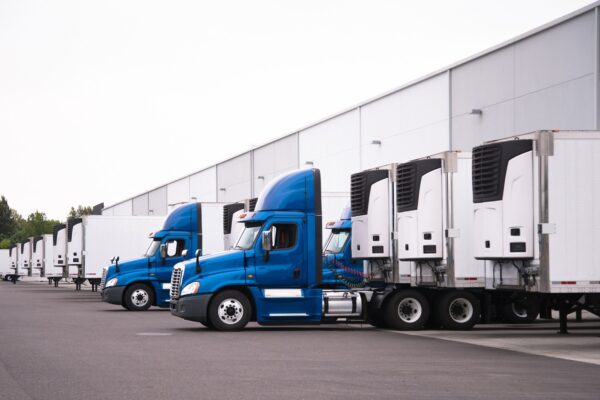 Semi trucks parked at warehouse loading docks. 