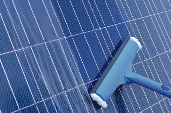 Closeup view of a squeegee cleaning a solar panel. 