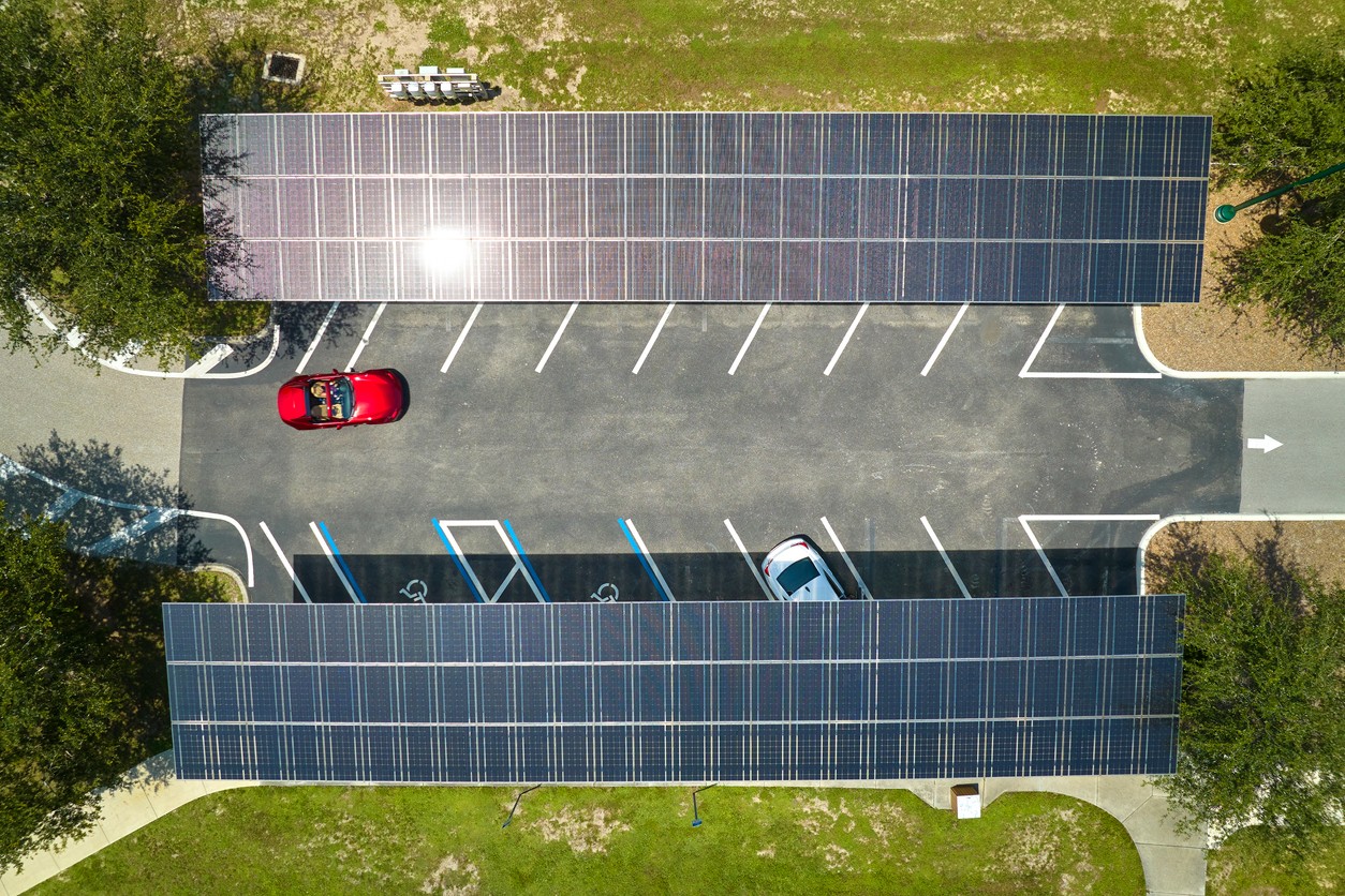 Aerial view of two solar carports with cars parked underneath them.