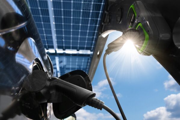 Closeup view of an electric charging station and vehicle being charged under a solar carport. 